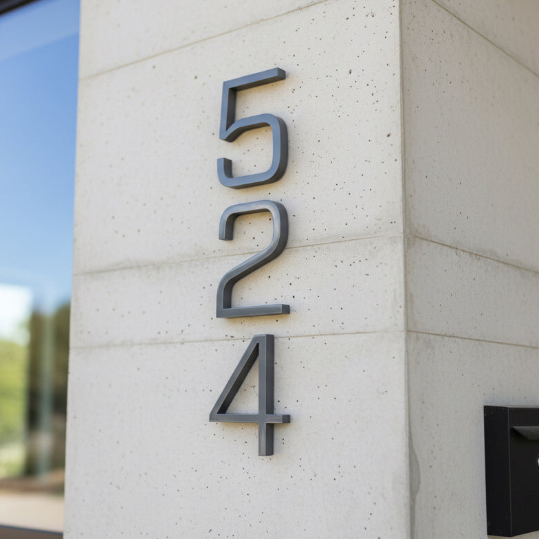 Modern house numbers '524' on a concrete wall.