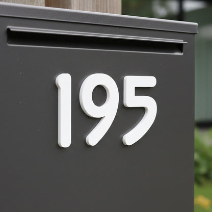 Black mailbox with white house numbers '195' on a blurred background