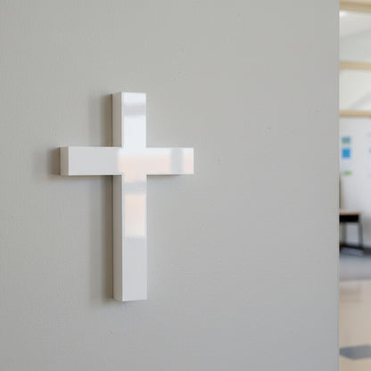 White cross wall light fixture on a gray wall