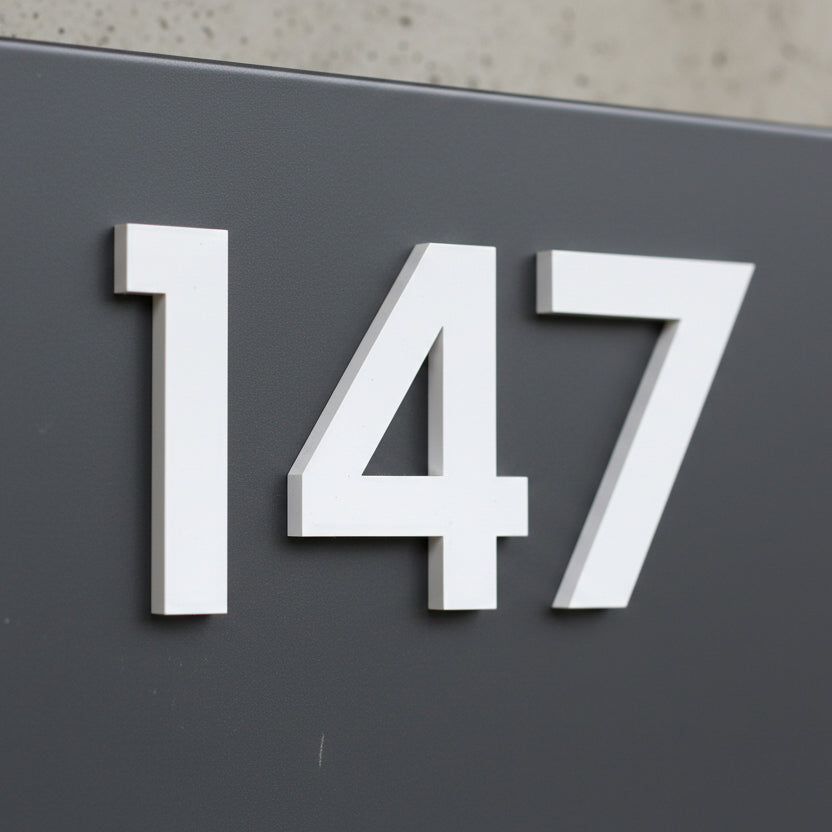 White house numbers '147' on a dark gray background