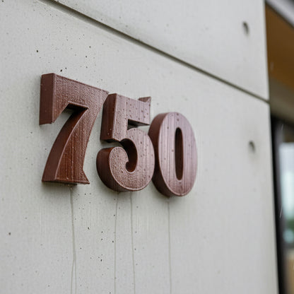 Wooden house numbers '750' on a light-colored wall.